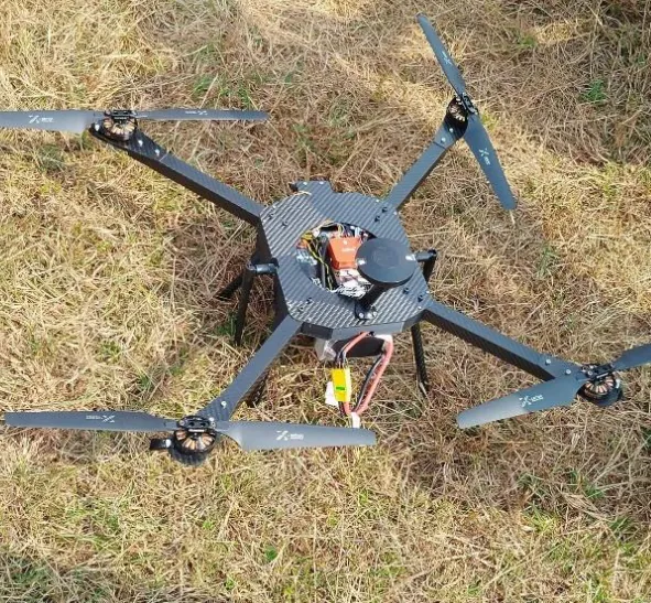 Surveillance drone with gimbal camera resting on grass
