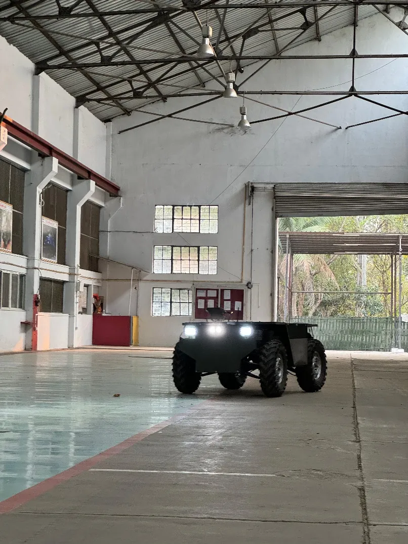 Autonomous UGV with headlights on inside a hangar